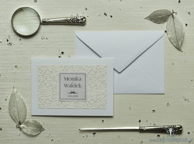 Eleganckie zaproszenia ślubne z cyrkonią oraz papierem ozdobnym przypominającym biało-srebrną grubą koronkę, na który przyklejony jest motyw tekstowy. ZAP-72-501 - ZaprosNaSlub