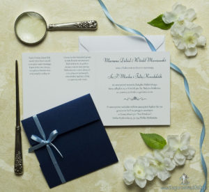 Przyciągające eleganckie zaproszenia ślubne z kwadratowym wnętrzem, wstążką koloru jasnobłękitnego i ciekawie wyciętą okładką z niebieskiego, perłowego papieru. ZAP-79-86