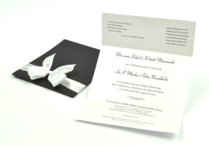 Ciekawe w formie eleganckie zaproszenia ślubne z wkładanym wnętrzem, białą wstążką oraz okładką z czarnego papieru ozdobnego z błyszczącymi elementami. ZAP-73-54