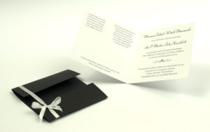 Przyciągające eleganckie zaproszenia ślubne z kwadratowym wnętrzem, wstążką koloru białego i ciekawie wyciętą okładką z czarnego papieru z błyszczącymi elementami. ZAP-79-88