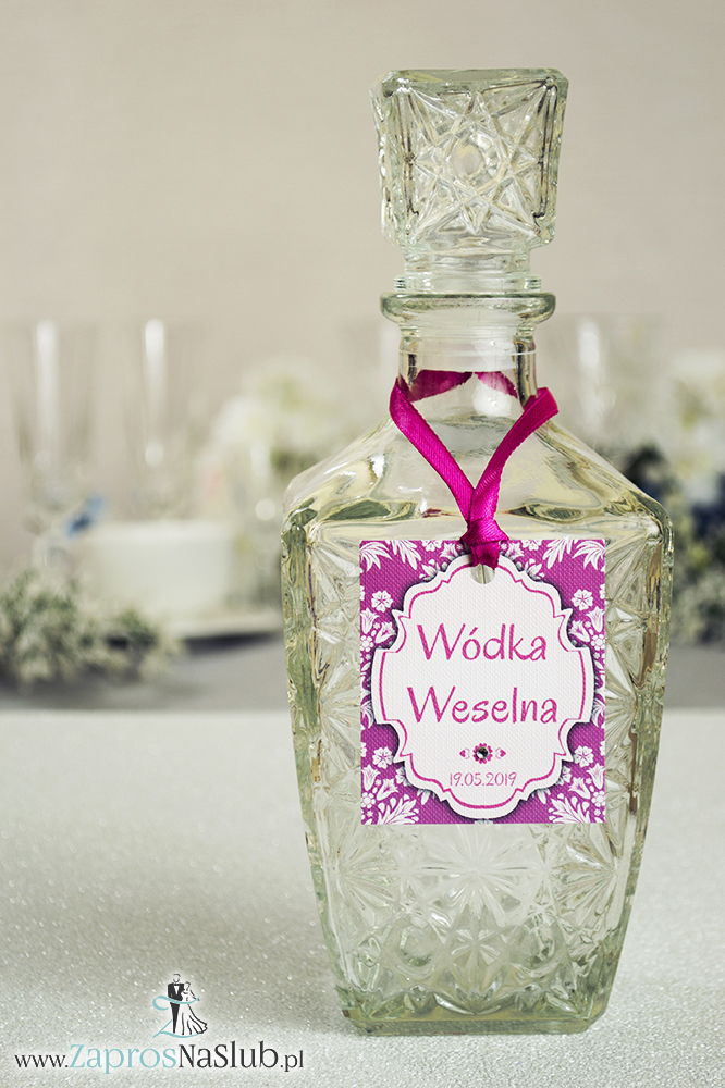 Zawieszki na alkohol z ornamentem. Elegancki różowo-biały florystyczny wzór, biały motyw ozdobny oraz satynową wstążka