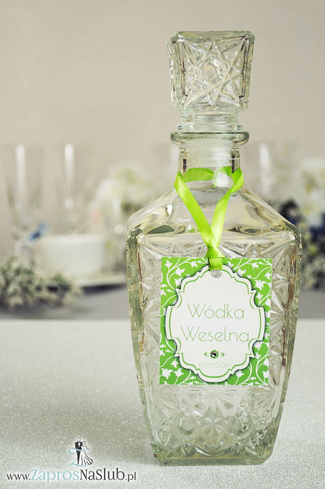 Zawieszki na alkohol z ornamentem. Elegancki zielono-biały roślinny wzór, biały motyw ozdobny oraz satynową wstążka