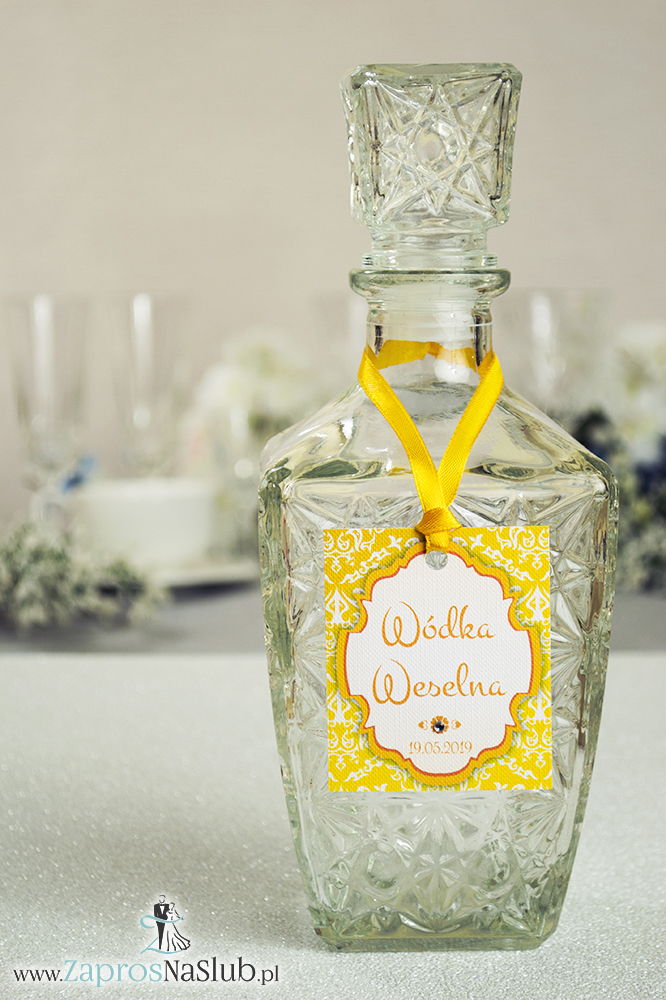 Zawieszki na alkohol z ornamentem. Elegancki żółto-biały wzór, trójkolorowy motyw ozdobny oraz satynową wstążka