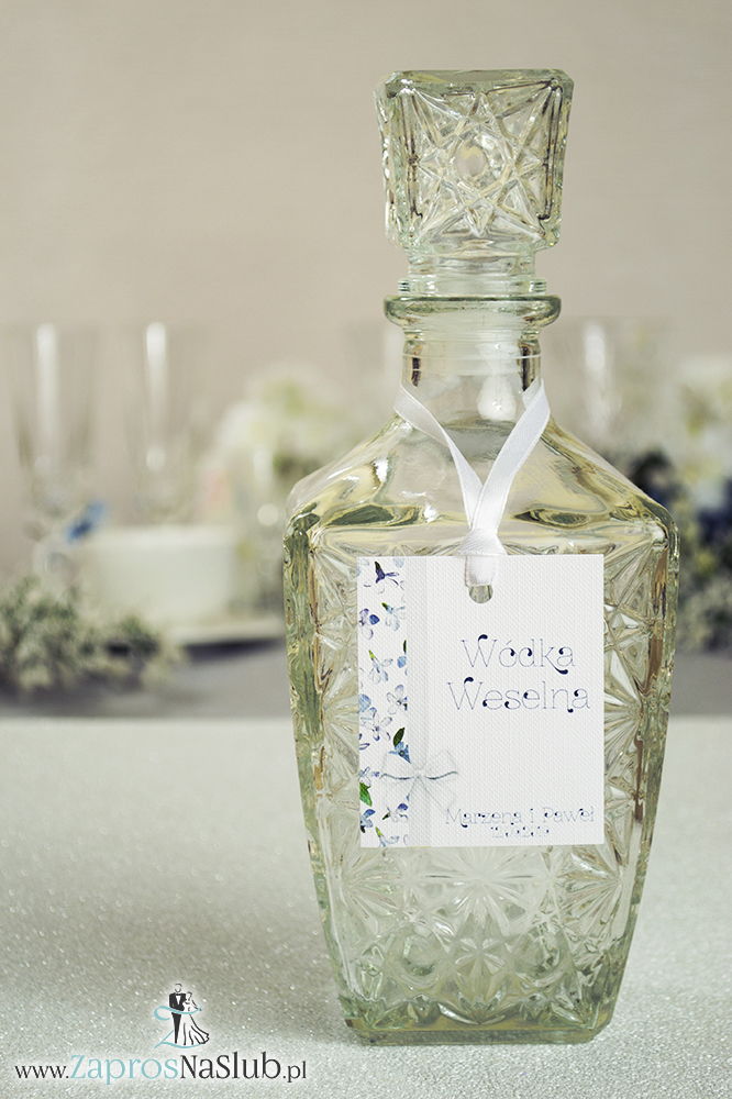 Kwiatowe zawieszki na alkohol wraz z białą wstążką i pionowym motywem niebiesko-białych kwiatów - ZaprosNaSlub