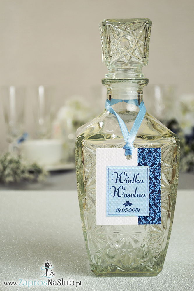 Zawieszki na alkohol z niebieskim barokowym ornamentem po prawej, przyklejanym motywem tekstowym i błękitną wstążką