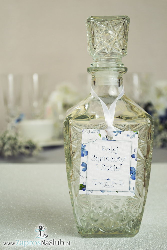 Kwiatowe zawieszki na alkohol wraz z białą wstążką i prostokątnym motywem niebiesko-białych kwiatów